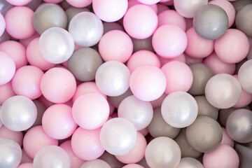 Playful pastel balls in pink, gray and white shades. Minimal, bright and soft background perfect for children’s themes, party design, banners, packaging and social media visuals