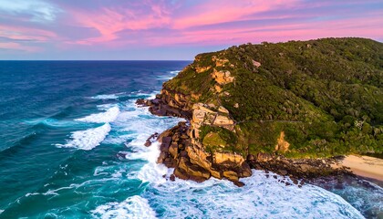 Coastal aerial view showcasing cliffs, ocean waves, and sunset colors