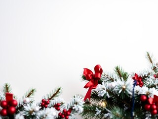Festive christmas border with snowy pine branches and red details.