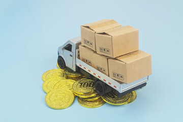 Lorry truck with many boxes on gold coins. Cost of freight transportation and tariffs concept