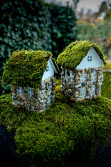 Miniature fairy houses with moss roofs in green garden