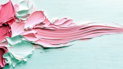 Thick, textured paint strokes in shades of pink and mint green are applied to a light blue surface, creating an abstract and visually appealing background.