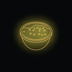 Neon yellow lentil soup is served in a bowl on a dark background