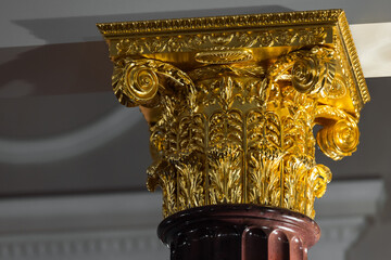 Fototapeta premium A richly detailed gold-leaf Corinthian capital with acanthus leaves and ornate scrolls