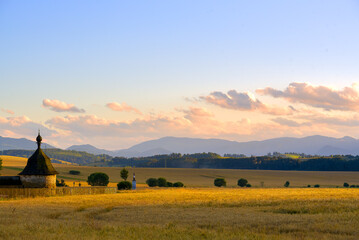 Sunset over the yellow field against mountains