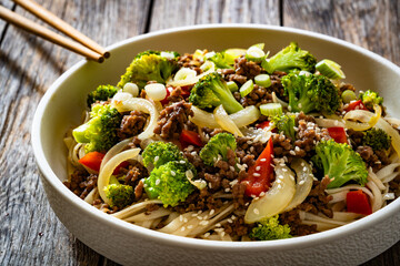 Ground beef and broccoli noodles on wooden table