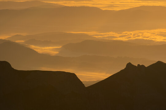 Aerial view of the rugged peaks and valleys bathed in the golden hues of the setting sun, Jahnaci stit peak, Presov Region, Slovakia.