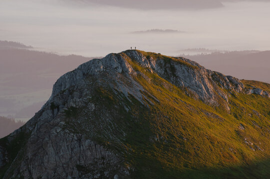 Aerial view of Jahnaci stit peak bathed in golden light, where silhouettes of hikers stand against the sky, Vysoke Tatry, Presov Region, Slovakia.