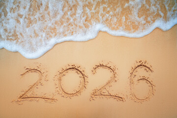 Happy New Year 2026 concept text on the beach sand tropical background