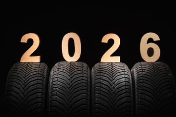 Car tires, winter wheels and text new year 2026 isolated on black background