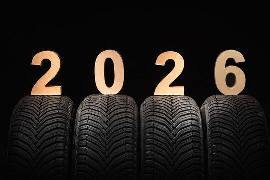 Car tires, winter wheels and text new year 2026 isolated on black background