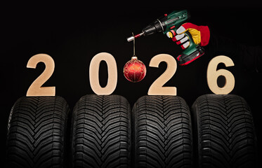 Winter car tires, big wheels service and hand of mechanic man with wrench and christmas ball, new year 2026 black  background