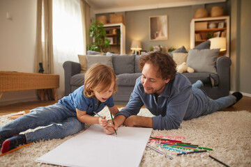 A joyful moment captures a parent and child actively engaged in drawing together on a large sheet...