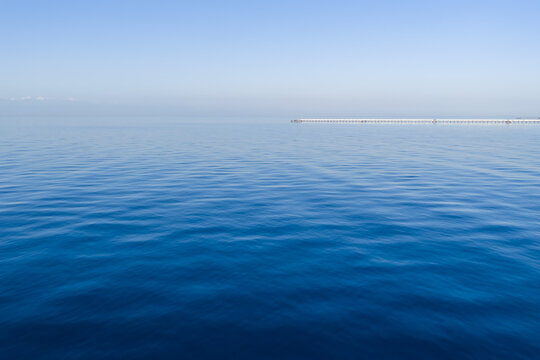 Calm blue sea with gentle waves under a clear sky. Minimalistic seascape with soft horizon and tranquil water texture - Powered by Adobe