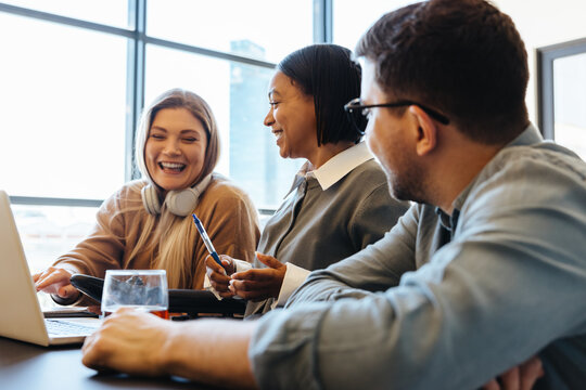 Three professionals sharing ideas in a modern office environment