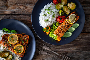 Baked salmon with white rice and Brussels sprouts on wooden table. Top view