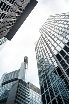 Architecture over Frankfurt corporate skyscraper finance framed by skyline reflection and a modern glass fa&ccedil;ade that forms sweeping vertical lines of distinct urban contrast atmosphere