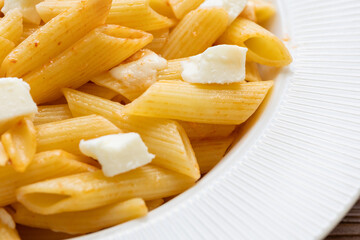 Close-Up of Penne Pasta with Cubed Cheese