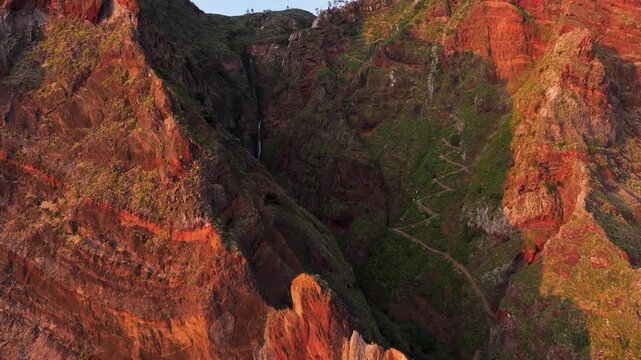 Sunset aerial view of Paul do Mar waterfall and zig zag mountain pass, Madeira