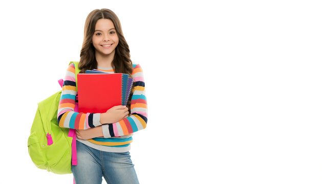 Young student girl wearing striped sweater holding textbooks and neon green backpack.