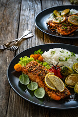 Baked salmon with white rice and Brussels sprouts on wooden table	