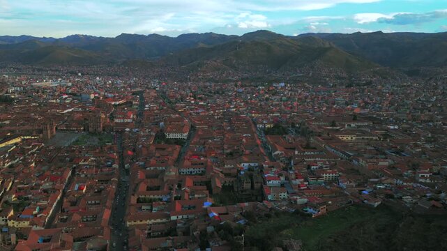 Cusco city Plaza De Armas street cityscape buildings Peru aerial drone late vive en el cusco Cuzco Saqsaywaman Anta province afternoon sunset rainy season clouds blue sky backwards motion