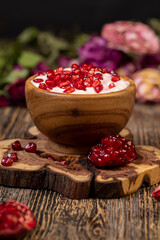 fresh pink yogurt and ripe red pomegranate seeds, delicious pomegranate-flavored yogurt and fresh red pomegranate