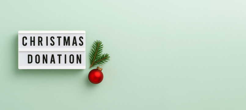 Christmas donation sign and ornament on light green background