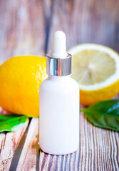 Natural skin care products with vitamin C and fresh juicy oranges on an orange background. Making a cosmetic product of cream, lotion, serum or essential oil.