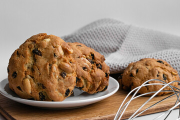 Closeup photo of delicious baked goods. Homemade cookies with raisins and peanuts on a wooden board.