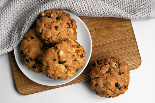 Top view cookies with nuts and raisins on a wooden board. Baked food on white plate photo. For food blog and recipe.