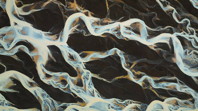 Aerial view of glacial rivers carve paths through the dark volcanic landscape, creating striking patterns of contrasting colors and textures, Landmannalaugar, Rangarbing ytra, Iceland.