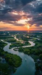 Stunning sunset aerial view of winding river cutting through lush green landscape, perfect for travel, adventure, or nature-themed projects