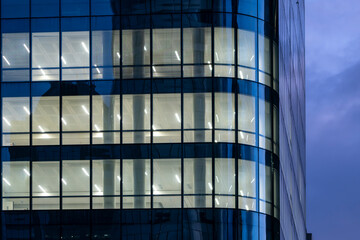 Nighttime corporate architecture showing reflection on office windows and a modern design urban facade enriched by blue hour tones for distinctive brand communication