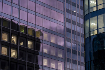 Modern design architecture featuring corporate office windows with reflection across an urban facade under blue hour night light for refined commercial imagery