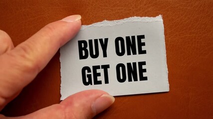 Buy One Get One message written on ripped torn paper background