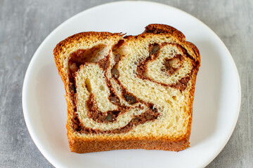 Slice of sweet marbled brioche plait with nuts and chocolate	