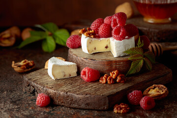 Camembert cheese with fresh raspberries and walnuts.