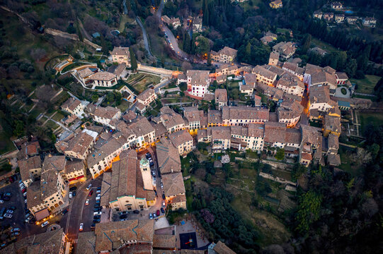 Aerial view of tiled roofs cascading down the slopes, nestled amidst verdant foliage and ancient structures, capturing the essence of Italian charm, Asolo, Veneto, Italy.