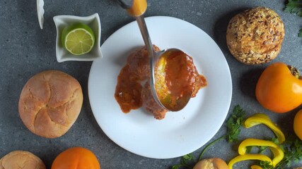 Flatlay video of chef serving meatballs with tomato sauce and assorted ingredients