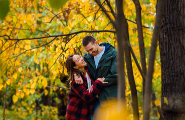 Happy interracial couple walking and holding hands in autumn forest.