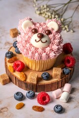 Adorable pink bear face cupcake decorated with fresh berries