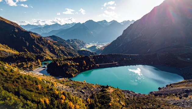 A stunning aerial view of a vibrant turquoise lake nestled in a mountain valley, with colorful autumn trees and rugged peaks under a clear blue sky. - Powered by Adobe