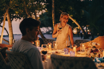 Family enjoying dinner with smiling matriarch at island resort