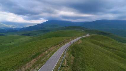The car is driving along a road in the Caucasus Mountains to the Dzhila-Su Valley