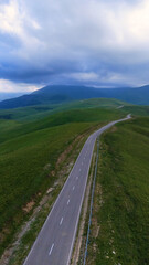 The car is driving along a road in the Caucasus Mountains to the Dzhila-Su Valley