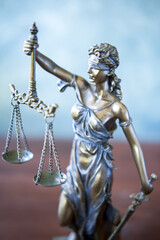 Statue of Themis Lady of Justice symbol on grey background.