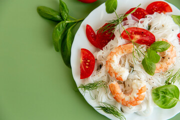 Appetizing noodles with seafood and tomatoes served on a plate