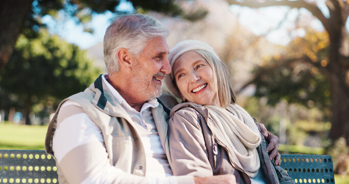 Retirement, bench and couple in park with hug, love and connection in healthy marriage. Romance, senior man and woman on outdoor seat with embrace, conversation and soulmate in happy relationship.