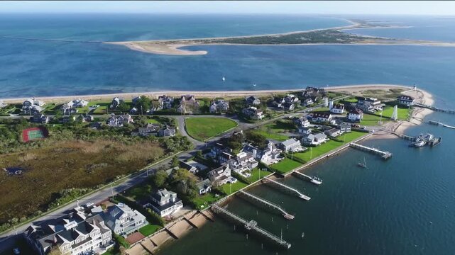 Aerial view of Brant Point Lighthouse, houses, and docks with boats, where the ocean meets the shore, creating a tranquil coastal vista, Nantucket, Massachusetts, United States.
